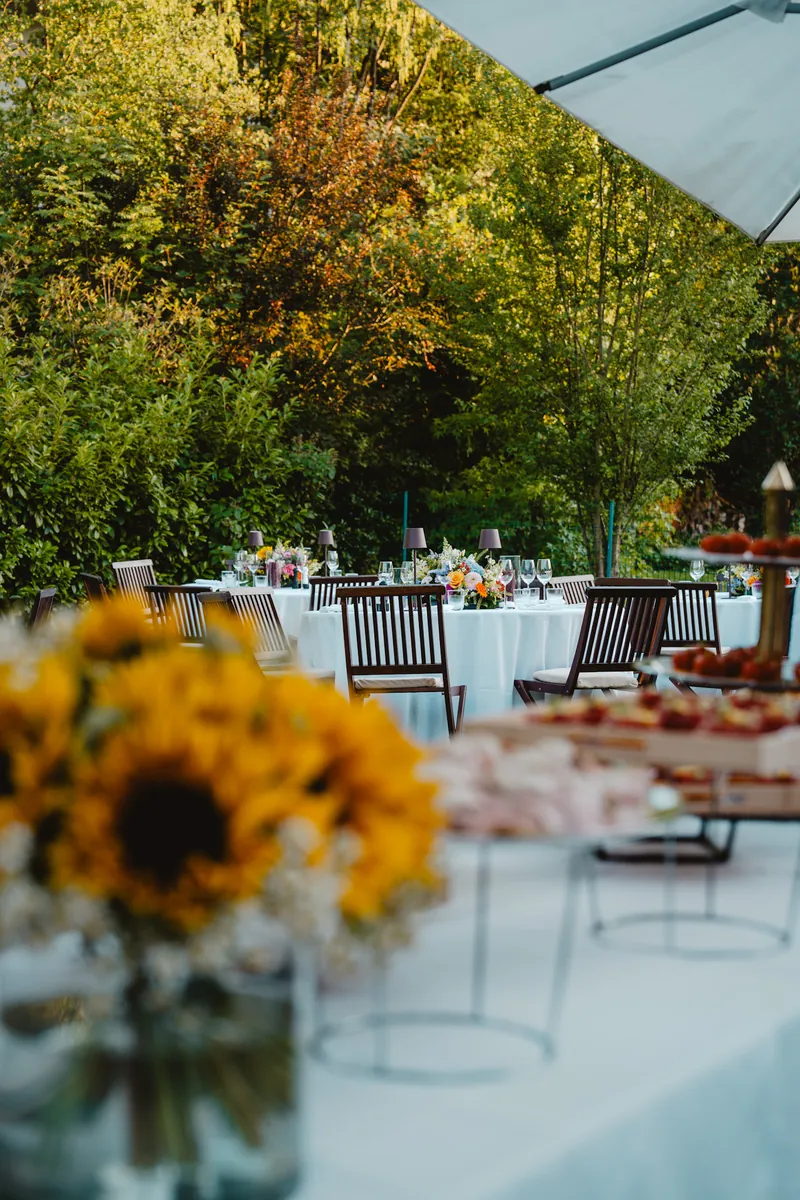 Tables dressées dans un jardin, vues à travers des tournesols