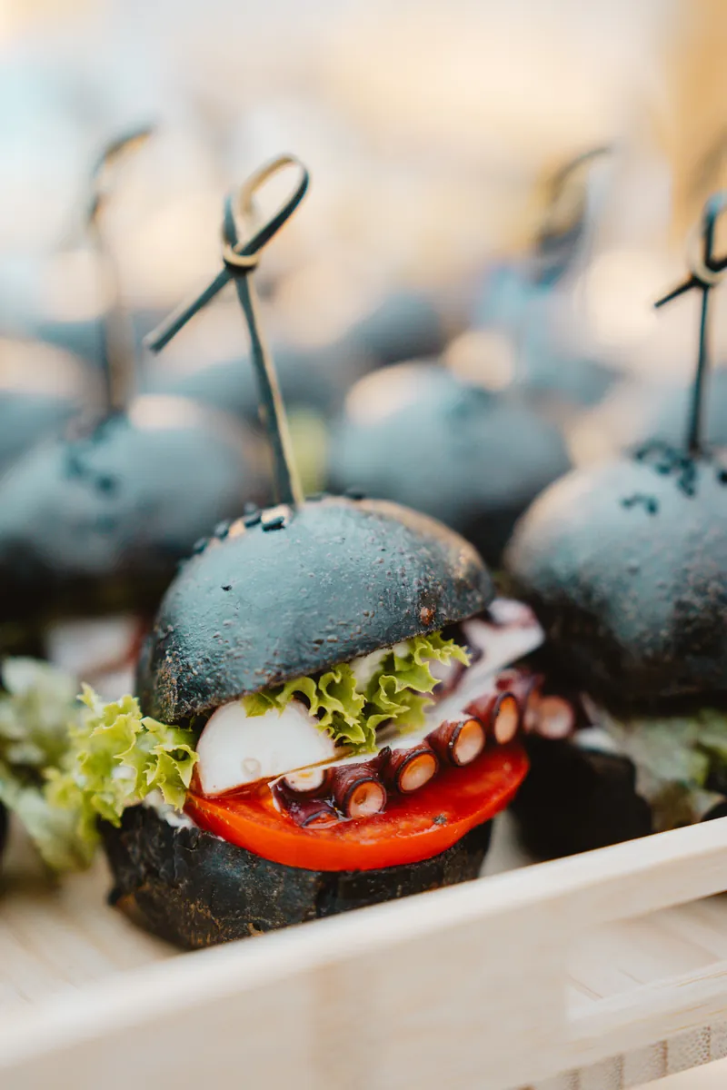 Burger noir au poulpe, tomate et salade