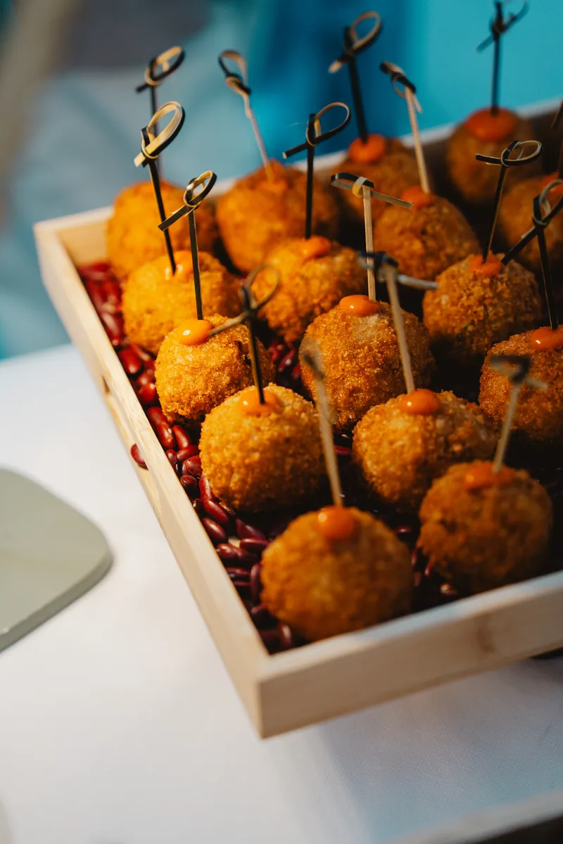 Arancini dorés piqués sur un plateau en bois